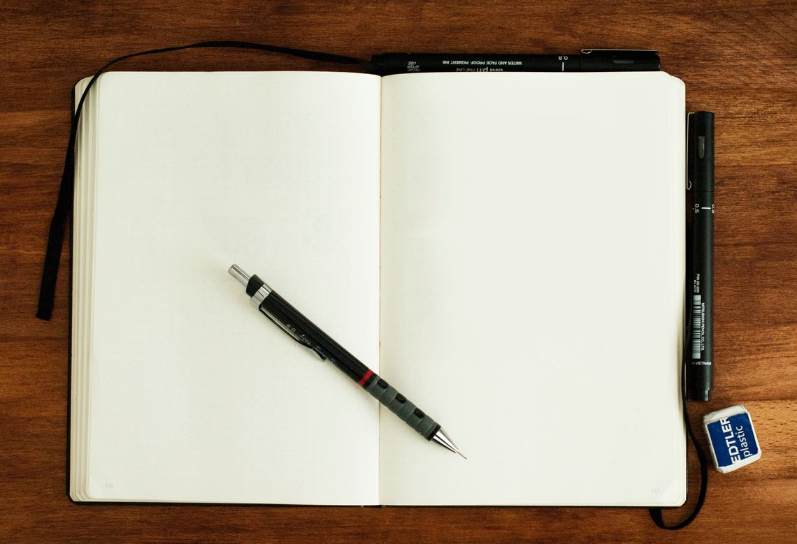 mechanical pencil resting on a blank open notebook
